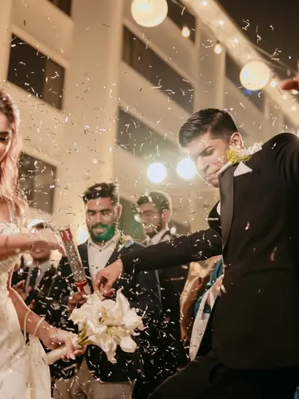 Caught in a storm of confetti, the couple dances with pure euphoria at their Christian wedding reception.
