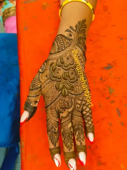 A beautiful and intricate design for the back of the hand. The central peacock motif is surrounded by delicate patterns, creating a very balanced look.