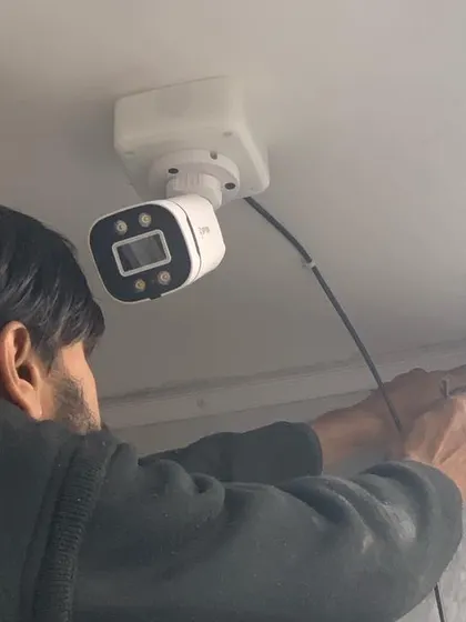 A technician at work, installing a camera with precision. We guarantee a professional job every time.