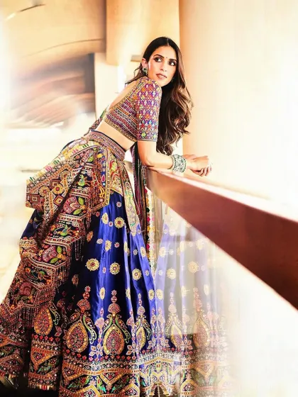 Happiest in colors! This vibrant, multi-colored lehenga is all about celebrating joy. The intricate embroidery and the rich blue base make it a standout piece for any grand celebration.
