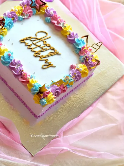A corner detail of the unicorn sheet cake, showing the gold unicorn horn and butterfly toppers.