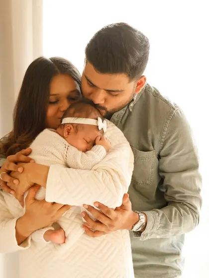 A perfect family portrait, holding their brand new baby. The love and awe in this moment are palpable.