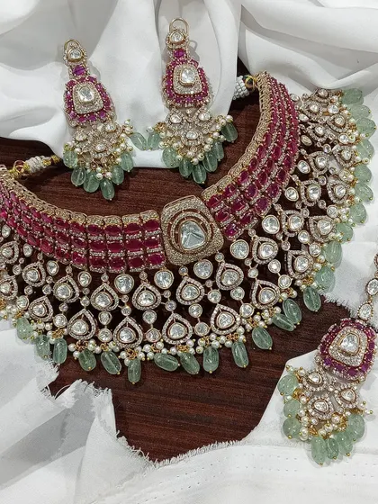 An exceptionally crafted bridal necklace set combining ruby-colored stones with mint-green bead drops. This piece demonstrates our ability to create complex, multi-colored designs with premium Moissanite stones for a rich, designer appeal.