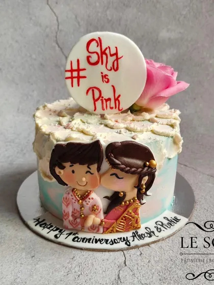 A cake to celebrate the first milestone. This half-kg Chocolate Caramel anniversary cake features a hand-painted couple in traditional attire, capturing a personal moment for the happy couple.