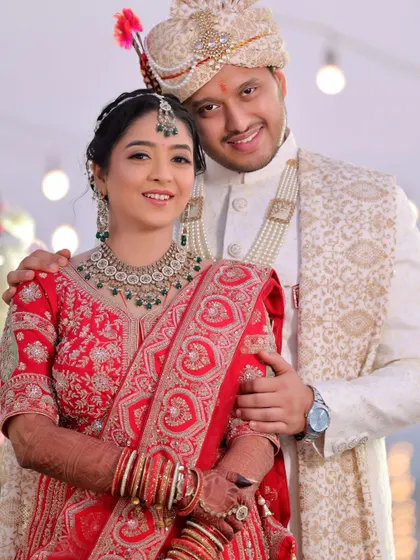 A traditional wedding portrait of the couple looking at the camera. This photo is perfect for family albums, capturing them in their full wedding attire.