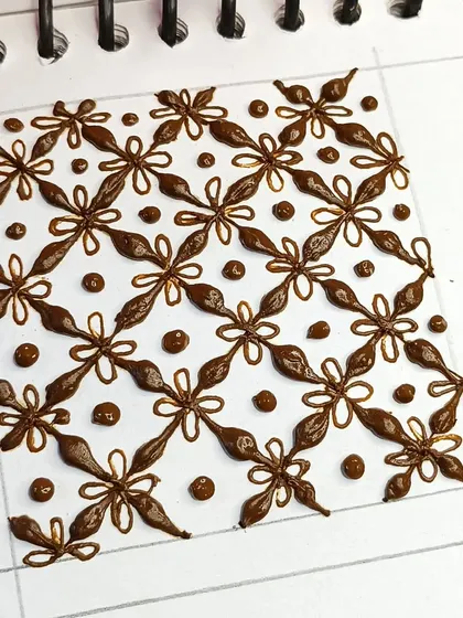 A close-up of a beautiful 3D-style grid pattern. This is an advanced filler technique that adds a lot of depth to your mehndi.