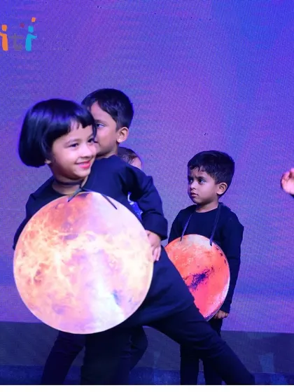 A smiling performer dressed as a planet. The joy on the children's faces is the best indicator of a successful event.