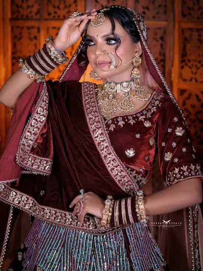A graceful pose where the bride adjusts her maang tikka. This shot captures the elegance of her movements and provides a closer look at her bridal jewellery.