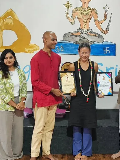 A student from our Thailand batch receives her certificate after a 10-day intensive workshop, surrounded by her teachers and peers.