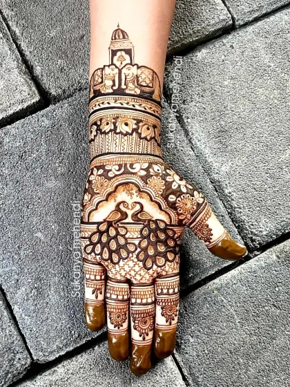 This Nag Panchami design combines traditional elements with personal touches, like the royal elephants and canopy, making it perfect for a bride celebrating the festival.