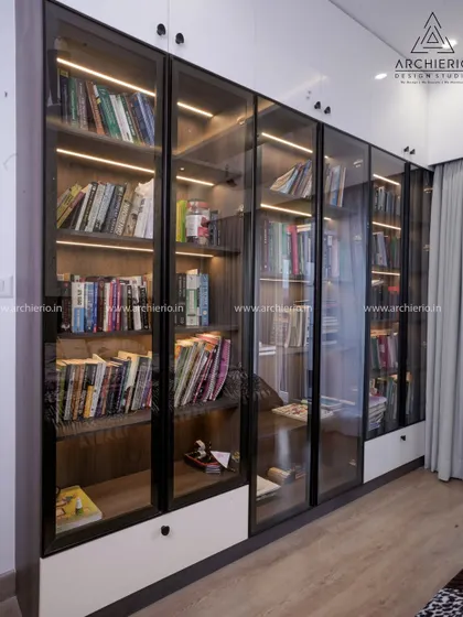 A floor-to-ceiling library or display unit with black-framed glass doors and internal lighting, perfect for showcasing books or collectibles.