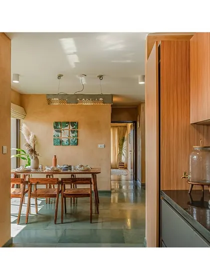 A view from the kitchen into the dining area. The use of natural wood and stone flooring continues throughout the ground floor, creating a cohesive and warm interior.