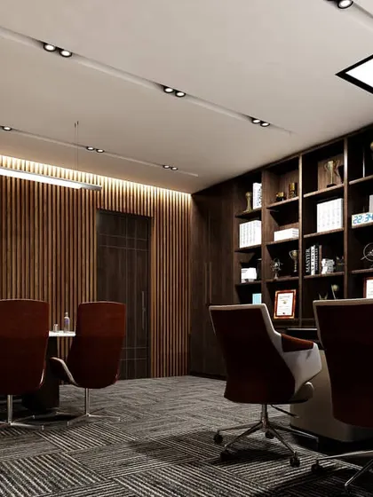 The conference area of the office, featuring a large meeting table and ergonomic chairs. The wood-slat wall and modern track lighting create a focused and professional setting for important discussions.