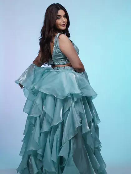 Feel like a princess in this dreamy, ruffled sky-blue lehenga. The layers of organza create beautiful movement, making it a fun and flirty option for a sangeet or daytime event.