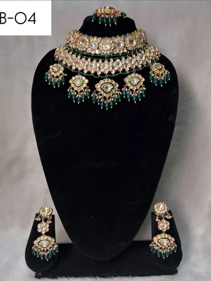 A beautiful choker set, B-04, featuring polki stones and hanging green bead details. This rental set is perfect for adding a touch of color and tradition.