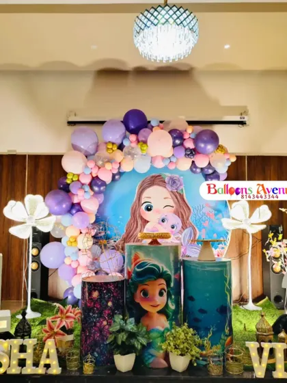 A frontal view of the elaborate mermaid stage decoration, highlighting the character backdrop and themed cake stands.