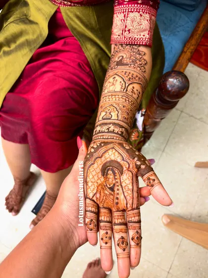 A close-up of the bride's hand, showing the detailed portrait of Radha. This level of detail is what makes my bridal mehendi special.