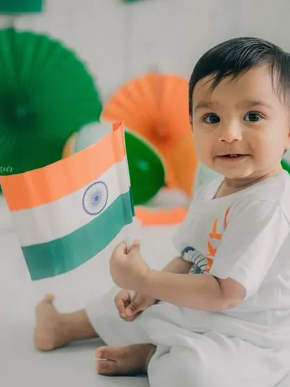 A lovely three-quarter profile shot as the baby holds the flag. This pose feels natural and shows off his adorable expression.