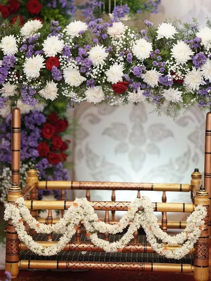 The cradle (thottil) is the heart of a naming ceremony. Here, I've decorated a traditional wooden cradle with a lush arch of white and purple flowers and delicate jasmine garlands.