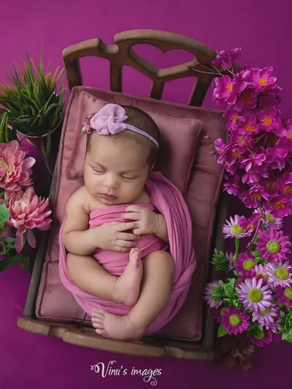 This overhead view shows the full composition of the floral bed theme, with the baby perfectly swaddled and positioned to look like she's floating in a garden.