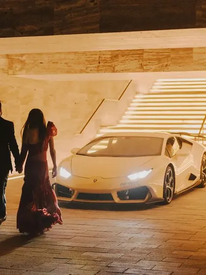 A glamorous shot of the couple with a Lamborghini, ready for their grand reception in Dubai. This image captures the luxury and excitement of a high-end city wedding.