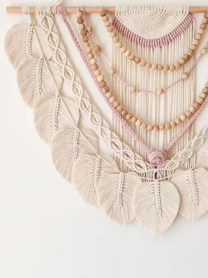 A side view of the large, beaded wall hanging with mauve accents, showing the beautiful cascade of macrame leaves.