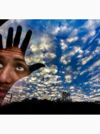 A self-portrait from my 'Reflections of Life' series. My face and hand are layered against a dramatic sky, creating a surreal image that speaks to a sense of wonder and connection with the world above.