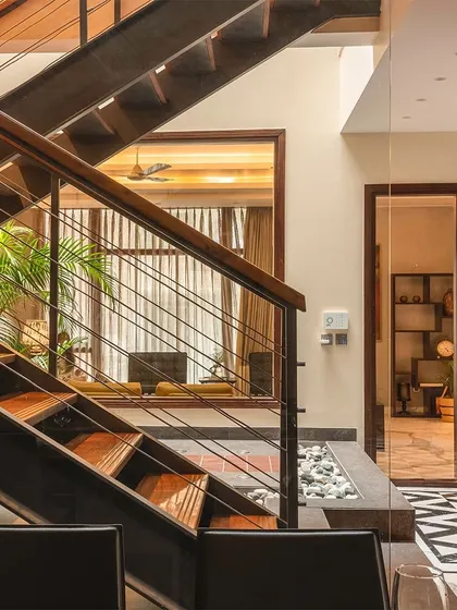 This staircase is more than just a way to get from one floor to another; it's a central architectural feature. The design integrates steel, wood, and cable railings, creating a light, transparent structure that connects the living spaces.
