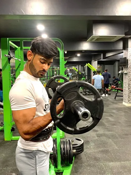 "The pain you feel today will be the strength you need tomorrow." A heavy barbell preacher curl.