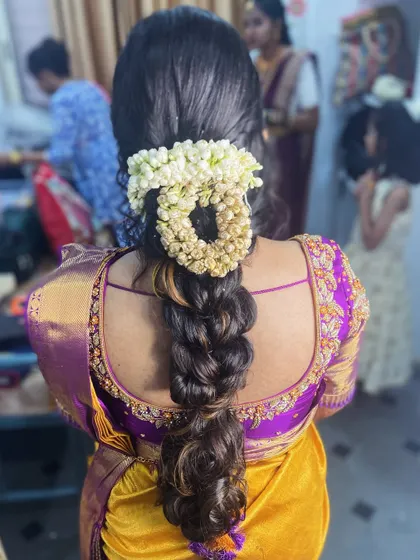 A modern take on a floral braid. This style uses a mix of braiding techniques and is adorned with a gajra for a fresh, contemporary look.