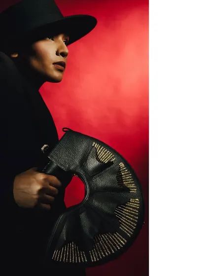 A profile shot from the 'Levels of Power' series, with the model emerging from the shadows. The red background adds a sense of passion or danger, while the lighting sculpts her features.