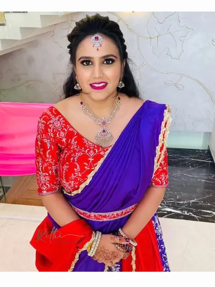 A lovely portrait of Poorva in her custom red and purple half saree, showcasing the vibrant colors and intricate embroidery of the blouse.