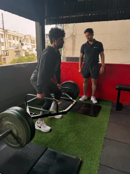 A client performing a heavy trap bar deadlift, a fantastic exercise for building full-body strength with less stress on the lumbar spine compared to conventional deadlifts.