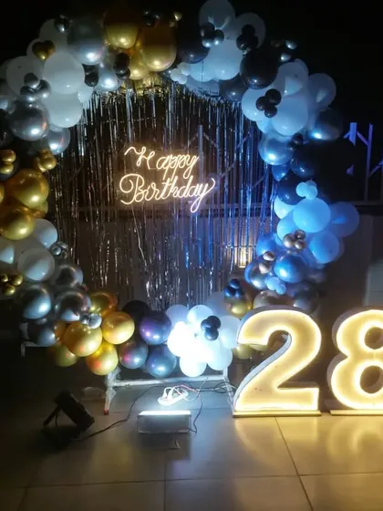 The party continues after dark with this glowing rooftop setup, where the neon sign and marquee numbers light up the celebration.