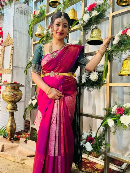 A happy client at a wedding reception. She is wearing a simple and elegant temple jewellery piece that is perfect for a guest who wants to look festive.