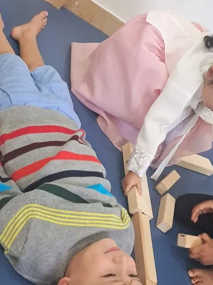 A child carefully places blocks alongside her friend, learning about measurement and spatial awareness through a fun, collaborative activity.