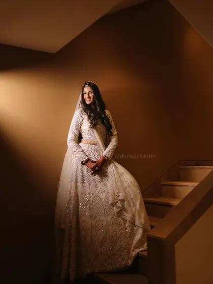 A full-length color portrait on the staircase, showing the bride in her beautiful attire.