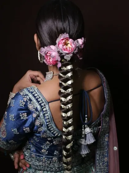 A hairstyle is just as important as the makeup. Here is a detailed look at an intricate traditional bridal braid, adorned with fresh flowers and gota patti, creating a classic and elegant finish for a wedding look.