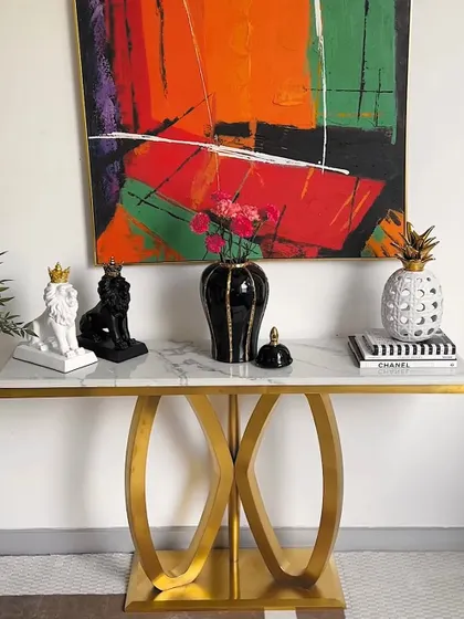 This image shows how different decor pieces can be arranged on a console table to create a stylish vignette. The monochrome lion showpieces and pineapple vase create a chic, modern look.