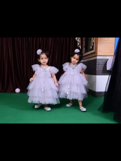 The twin girls in their matching lavender birthday frocks, complete with cute hair accessories.