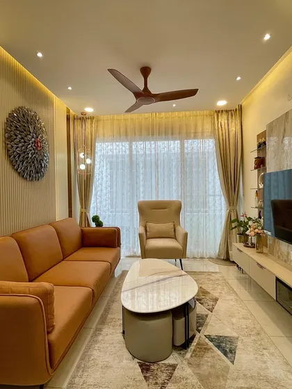 This living room combines warm tones and rich textures for a cozy yet sophisticated feel. The tan leather sofa is paired with a plush armchair and a modern coffee table, all anchored by a geometric rug.