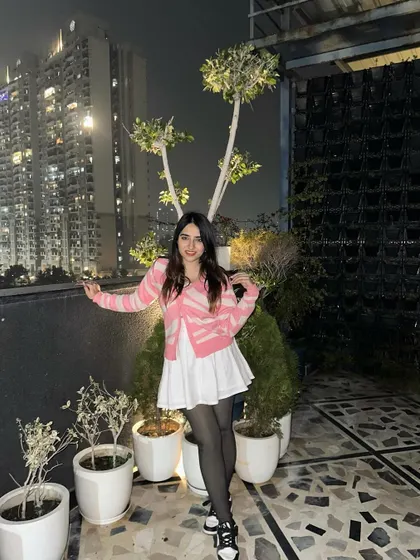 A cute and preppy look with a pink and white cardigan and a white skirt. This is a great outfit for a casual evening outing.