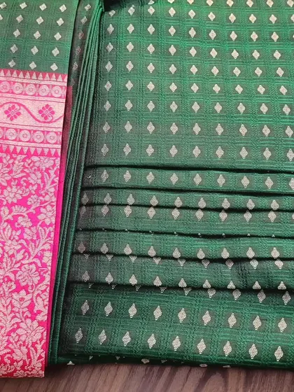 A client's green and pink silk saree, pre-pleated and ready for her event.
