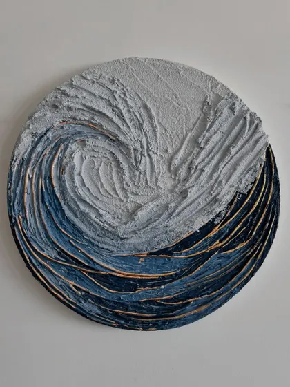 "Whispers of the Wave," a circular piece that captures a cosmic swirl of crashing waves and quiet storms. Sculpted with moody blues, whites, and golden glimmers, it tells the ocean's story without a word.
