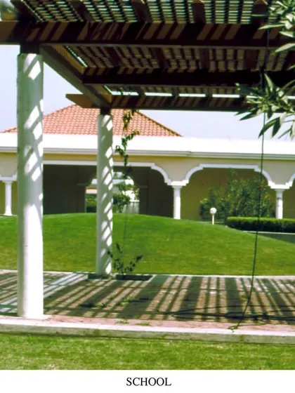 Another view of Babrala School from 1996, showcasing the interplay of light and shadow created by the pergola. The design uses simple architectural elements to create a comfortable microclimate and a visually interesting pathway for students.