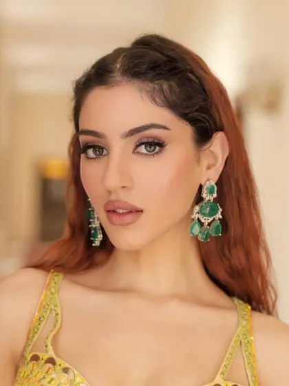 A fresh and sunny look perfect for a Haldi or Mehendi function. The bright yellow outfit is paired with statement emerald chandelier earrings, creating a vibrant and joyful ensemble.