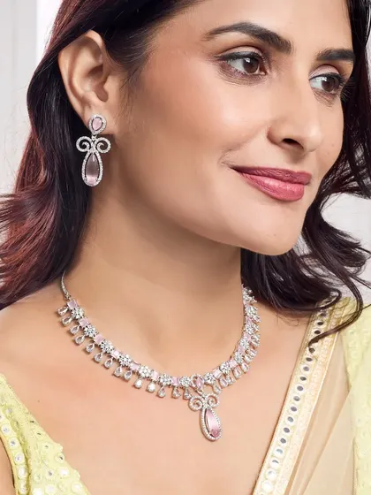 A close-up on a model wearing a delicate diamond and pink gemstone necklace set, perfect for showcasing modern, fine jewellery collections.