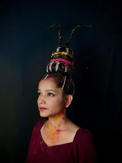 A whimsical and creative hairstyle featuring a sculpted, multi-layered bun. This type of styling is perfect for fantasy themes and allows students to experiment with shape and form.