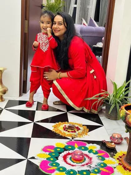 A client and her daughter celebrating Diwali in our coordinated tomato red peplum and tulip pants sets. It's wonderful to see families creating memories in our custom designs.
