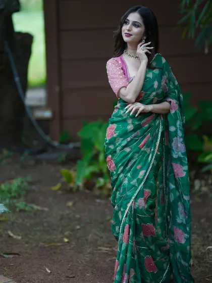 A beautiful green floral silk organza saree, paired with a contrasting pink hand-embroidered blouse.